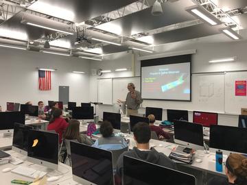 Technology teacher lecturing students in classroom